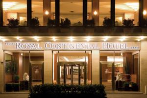 a building with a royal continental hotel at night at Hotel Royal Continental in Naples