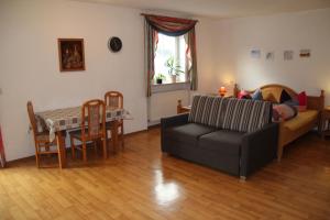 ein Wohnzimmer mit einem Sofa und einem Tisch in der Unterkunft Pension & Ferienwohnung Breitmoser Angelika in Riedenburg