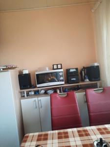 a room with two red chairs and a tv on a shelf at Haus am Donatsturm in Freiberg