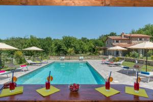 セッジャーノにあるPangea Villa 8 - Usually min 7 nightsのスイミングプール(テーブル、椅子付)の景色を望めます。