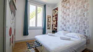 - une chambre avec un grand lit blanc et une fenêtre dans l'établissement Mamie Jane co-munity, à Aix-les-Bains