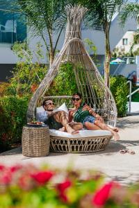 two men laying in a hammock on the beach at Sofianna Resort & Spa in Paphos