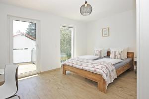 a white bedroom with a bed and a window at Alpspitzblick in Oy-Mittelberg