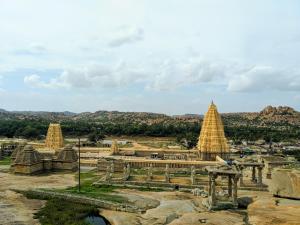 a view of a temple with mountains in the background at Hotel Varsha Hampi in Hampi