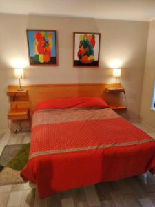 um quarto com uma cama vermelha e 2 candeeiros em Laguna Vista em Algarrobo
