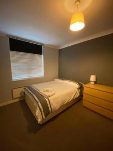 1 dormitorio con cama, ventana y vestidor en Little Church Street, en Rugby