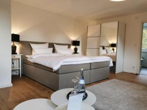 ein Schlafzimmer mit einem großen Bett und zwei Tischen in der Unterkunft Fuchs'sche Mühle in Weinheim