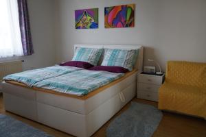 sypialnia z łóżkiem i żółtym krzesłem w obiekcie Vorstadt-Appartement Haus Monika w mieście Äußere Ragnitz
