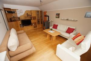 a living room with two white couches and a table at Ferienwohnung Steiner Gertrude in Gaming