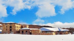 ein großes Backsteingebäude mit Schnee auf dem Boden in der Unterkunft Aqua Montis Resort & Spa in Rivisondoli