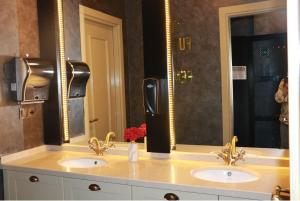 a bathroom with two sinks and two mirrors at Air Boss Giresun City Hotel in Giresun