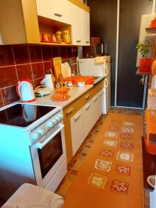 a kitchen with white cabinets and a stove top oven at Apartment Sunce in Sremska Mitrovica