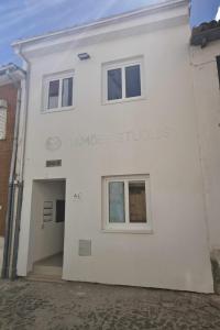 a white building with the words cambridge studios on it at Camoes StudioGeral in Bragança