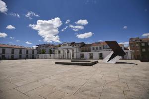 a sculpture in a courtyard in front of a building at Camoes StudioGeral in Bragança