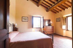 Schlafzimmer mit einem Bett, einer Kommode und Fenstern in der Unterkunft Appartamenti con cucina nelle colline toscane in Anghiari