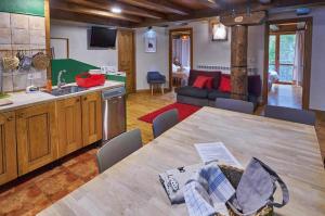 cocina y sala de estar con una gran mesa de madera. en Casapirineos Apartamentos en Ulle