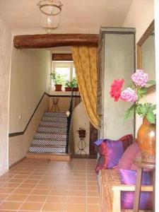a living room with a staircase with a couch and flowers at Bonito apartamento para 2 personas in Castejón de Sos