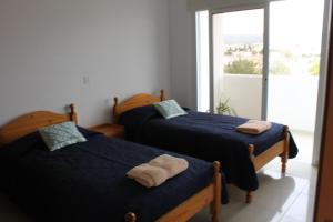 2 camas en una habitación con ventana en Galatia's Court, en Pafos