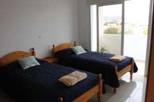 two beds in a room with a window at Galatia's Court in Paphos