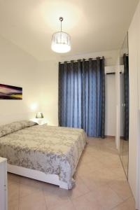 1 dormitorio con cama y cortina azul en Afrodite appartamento Ballarò, en Palermo