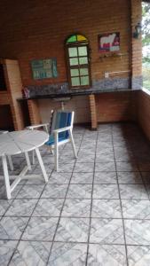 an outdoor patio with a table and a chair at Chacara estilo Chale in Roças Novas