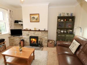 a living room with a couch and a fireplace at Kelda Garthr Tranquil Garden in Leyburn