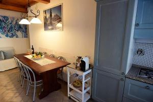 a kitchen with a wooden table and a dining room at CASA MAIRA IN CENTRO A SATURNIA in Saturnia