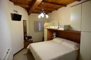 a bedroom with a bed and a television in it at CASA MAIRA IN CENTRO A SATURNIA in Saturnia
