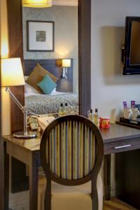 a desk with a chair and a bed in a room at Norfolk Royale Hotel in Bournemouth