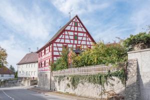 un grand bâtiment rouge et blanc à côté d'une rue dans l'établissement Ferienwohnung Säntisblick, à Radolfzell am Bodensee
