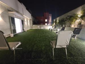 una stanza con sedie e pavimento verde con piante di Hotel Orange International a Surat