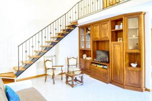 a living room with a staircase and a tv at LUIGINA House in Levanto