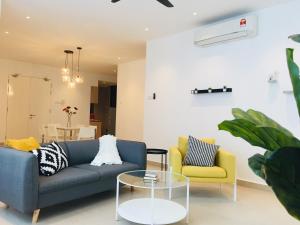uma sala de estar com um sofá azul e duas cadeiras em KLGateway Premium Residence Mid Valley em Kuala Lumpur