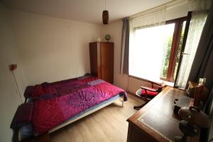 een slaapkamer met een bed, een raam en een bureau bij Appartement - Kievitenlaan 1 Veere 'Nescio' in Veere