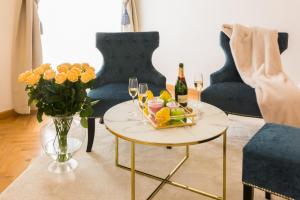 ein Wohnzimmer mit einem Tisch mit Champagner und Blumen in der Unterkunft Palais Gutenberg l´atelier in Klagenfurt am Wörthersee
