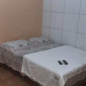 duas camas num quarto com dois chinelos na cama em Hospedagem recanto da lua em Maragogi