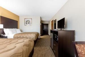 a hotel room with two beds and a flat screen tv at Quality Inn & Suites Metropolis I-24 in Metropolis