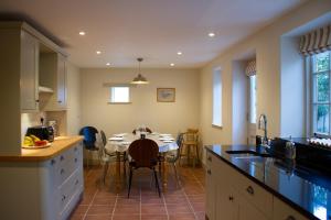 een keuken met een tafel en een eetkamer bij Ford End Cottage in York