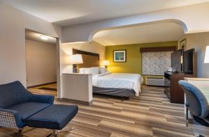 a hotel room with a bed and a chair at Country Inn & Suites by Radisson, South Haven, MI in South Haven +34 photos