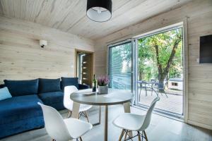 a living room with a blue couch and a table and chairs at OkejAparts in Wilkasy