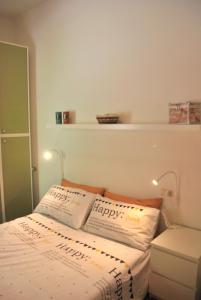 een kleine slaapkamer met een bed met 2 kussens bij Appartamento Nadia - Theater Home in Tignale