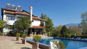 a house with a swimming pool in front of it at Hotel Villa Ofir in Sandanski