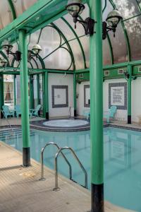 an indoor swimming pool with green columns and water at Norfolk Royale Hotel in Bournemouth