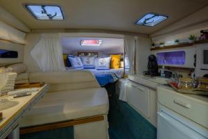 a small room with a bed and a kitchen at SLEEPBOAT Barco Hotel Oporto Douro in Porto