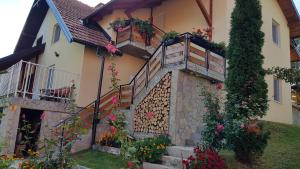 a house with flowers on the side of it at Zlatibor Apartmani DM Tornik in Zlatibor