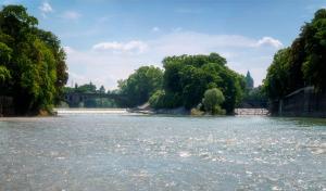 a view of a river with a bridge and trees at Holiday Inn Munich City Centre, an IHG Hotel in Munich