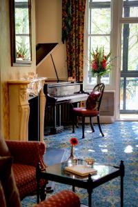 a living room with a piano and a table at Norfolk Royale Hotel in Bournemouth