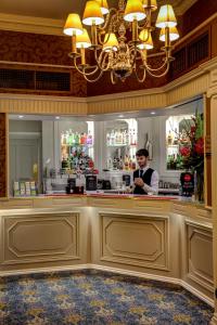 a man standing behind a bar in a restaurant at Norfolk Royale Hotel in Bournemouth