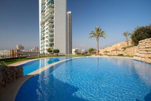 a large swimming pool in front of a tall building at Luxury apartment on the 41st floor with stunning sea views in Benidorm