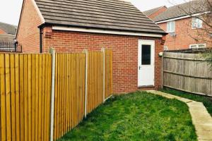 a wooden fence in front of a house at Smartrips Home Coventry in Parkside